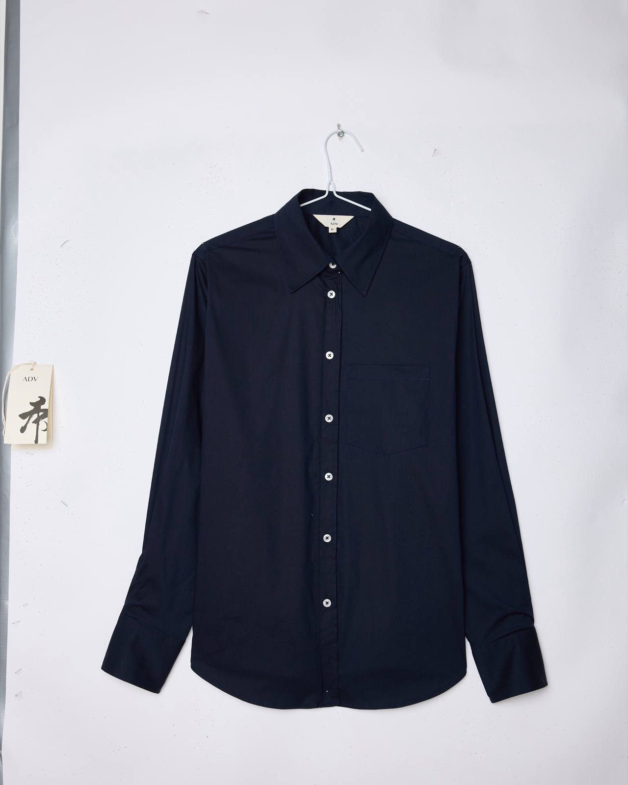 Raw product input — a single ADV garment, shot front-on on a phone